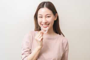 Dental,Invisible,Braces,,Beautiful,Smiling,Asian,Young,Woman,Holding,Invisalign